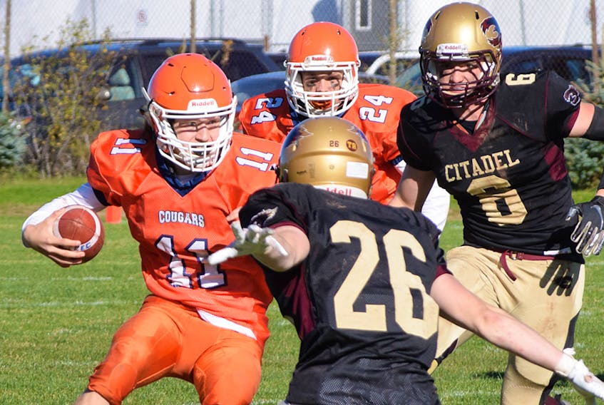 Craig Tabor of the CEC Cougars takes the ball wide against a couple of Citadel defenders in NSSAF high school football league action Sunday in Truro. Tabor scored CEC's only TD in a 28-7 loss to Citadel, though just seven points separated the teams heading into the final quarter.