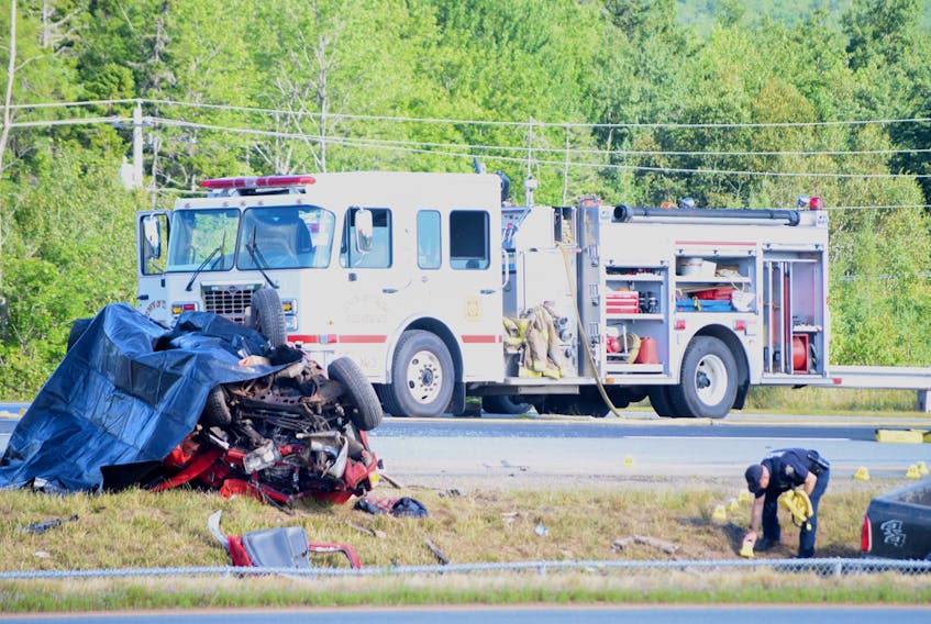 A police officer inspects the crash scene on Hwy 102's northbound lane near Millbrook First Nation on Tuesday afternoon. The collision forced police to close the lane off and divert traffic onto the old Hwy 2 into Truro from Brookfield.