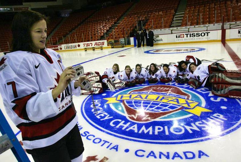 Team Canada captain Cassie Campbell is seen checking her camera while photographing teammates posing on the 2004 world women's hockey championship logo following their team picture at the Halifax Metro Centre. Truro and Halifax will host the 2020 world women's championship.