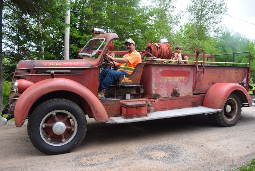 John MacKay, chief of the North River and District Fire Brigade, takes a short cruise in the 1939 International fire truck pumper recently given to him by a relative. The pumper was in service with the Trenton, N.S. Fire Department from 1939 to 1962. Seen with MacKay are his sons, Lucas (in front seat), and Brisin.