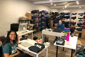 My Home Apparel employees Amy Allain, Shekara Grant and Maddie Richards are seen working on the new "Stay the blazes home" T-shirts that are being sold as a charitable fundraiser.