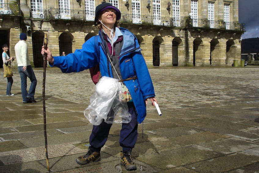 A jubilant pilgrim on Spain's Camino de Santiago marks the end of her journey in front of the cathedral in Santiago de Compostela.