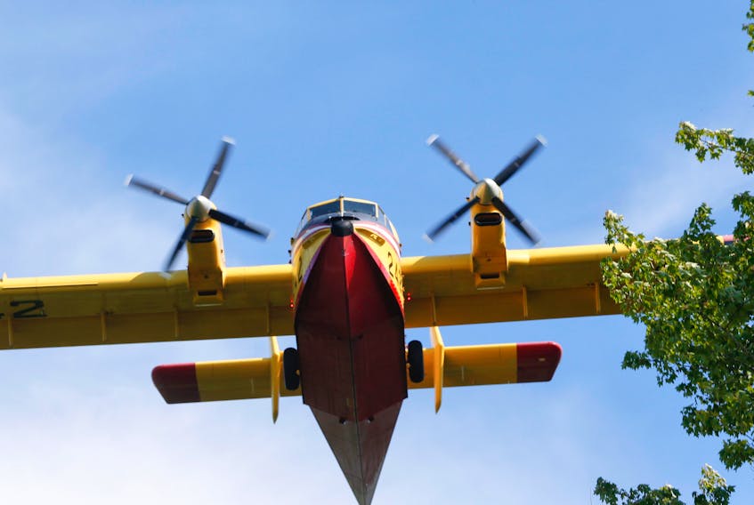 A water bomber makes a pass while fighting a forest fire near Ten Mile Lake, Queens County, N.S., on July 10, 2016