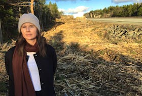 Halifax resident Teresa Fisher is shown standing along Highway 102 where crews have been cutting further into the treeline. She calls the cutting excessive and is frustrated by the lack of public consultation.