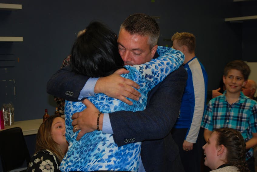 Lloyd Parrott hugs his wife following his victory in Terra Nova district on election night in Newfoundland and Labrador.