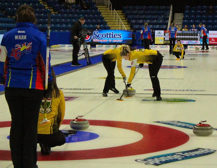 From the left, Team British Columbia skip Sarah Wark and Team Manitoba skip Tracy Fleury watch as Team Manitoba curlers Selena Njegovan and Kristin MacCuish sweep a stone thrown by Liz Fyfe during Thursday morning’s tie breaker at the Scotties Tournament of Hearts.