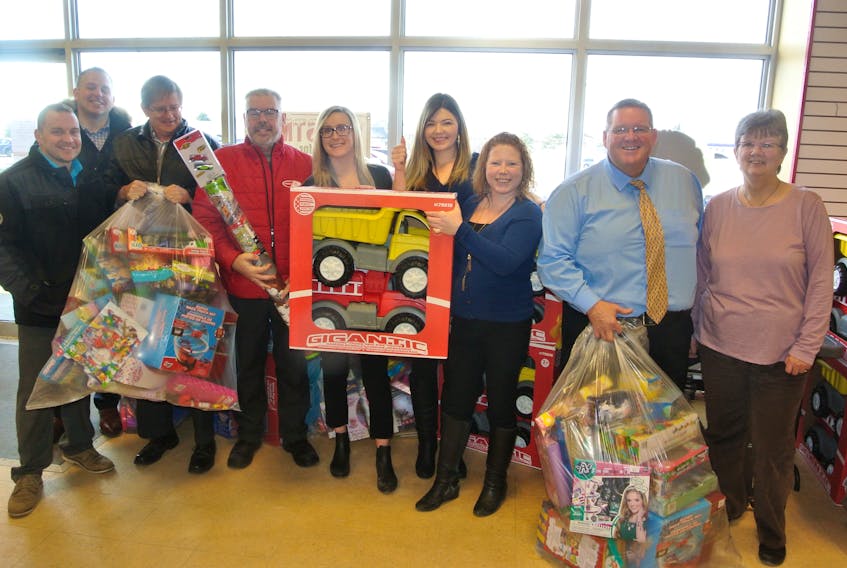 Staff from Amherst Toyota went to the Amherst Christmas for Kids office on Dec. 11 to present toys from its toy drive to the program that makes sure every child has a gift under the tree on Christmas morning. Barbara Baxter of the Amherst Lions Club (right) accepts the gifts from (from left) used car manager Troy Williams, business manager Murray Meldrum, product advisors Wayne Murray, Steve LeBlanc, Shelby Colton and Jackie Steele, financial specialist Katie Spicer and sales manager Mike Morris.