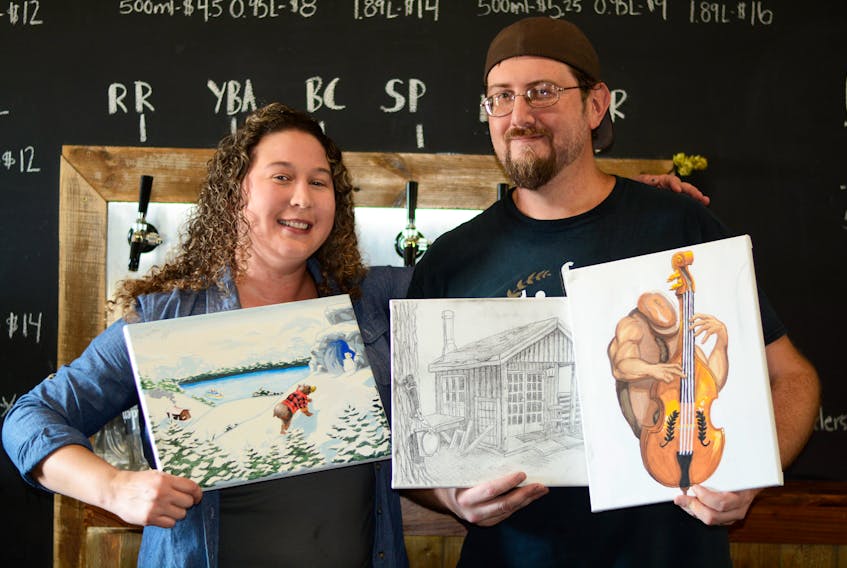 Trider’s Craft Beer co-owner Laura Parker and her brother-in-law Ken Potter work together to create the fun, unconventional labels found at Trider’s Craft Beer. She pitches concepts to him and he brings them to life through his drawings. Laura is holding Ken’s painting for the Hibrrrnation Winter Ale, and Ken is holding his drawings for the Maccan Maple and Mean Joe Bean beers. The shed depicted in the Maccan Maple label is located on Trider Road in Maccan where Trider’s began brewing beer before moving to their current facility in Amherst.