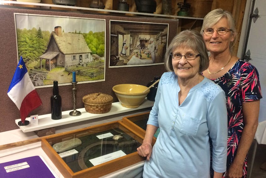 Lorna Lord, left, and Fran Albrecht, Board Members of the Tryon & Area Historical Society Inc.,  put finishing touches on the Acadians in Tryon Display at the Tryon Museum.