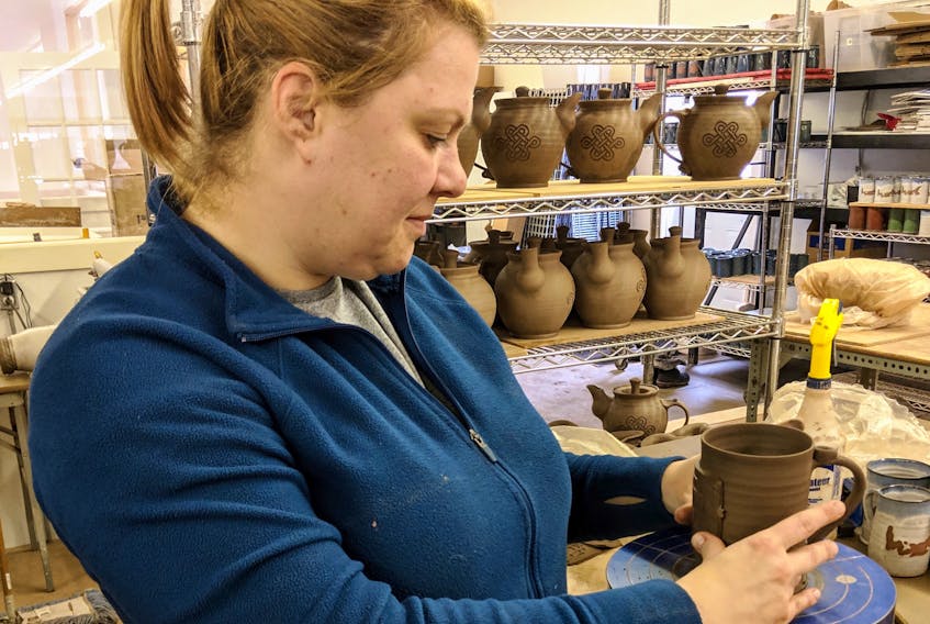 Tunde Szarka, hand building a custom mug at Island Stoneware studios. Szarka has worked with Island Stoneware for five years.
