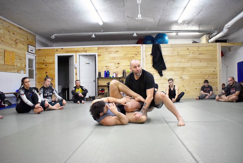 Instructor and owner of Pictou County jiu-jitsu, Jaret Macintosh demonstrating how to get past Liam Walsh's guard.