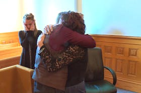 Philip Butler shares an emotional hug with his girlfriend as another supporter looks on in Newfoundland and Labrador Supreme Court Saturday morning, minutes after hearing he had been acquitted of killing his brother.