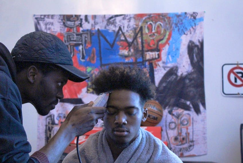 Travis Edwards gets his hair cut by Luke Ignace at his apartment barber shop, Urban Kutz. Ignace is working to get funding and secure a space to run the business.