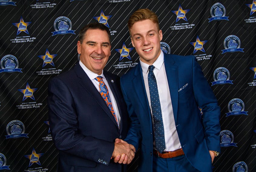 Quebec Major Junior Hockey League commissioner Gilles Courteau, left, congratulates Charlottetown Islanders goalie Matthew Welsh for winning the scholastic player of the year award Wednesday in Quebec City.