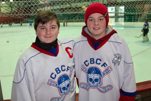 Twelve-year-old Kristian (Champ) MacKenzie of Reserve Mines, left, and Cole MacDougall, 13, of Glace Bay are shown wearing Cape Breton Correctional Facility staff team jerseys. Cole’s jersey was customized to honour his late father, Shane, who died in June of 2018. T.J. COLELLO/CAPE BRETON POST