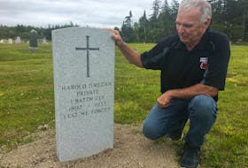 Dara Legere kneels beside a new headstone for Pte. Harold O’Regan, who is buried in the Ragged Reef cemetery near Joggins. The Last Post Fund paid for the new headstone for O’Regan, whose First World War medal was found on the beach at Lower Cove in August 2018 by metal detector Dean Brown and his wife.