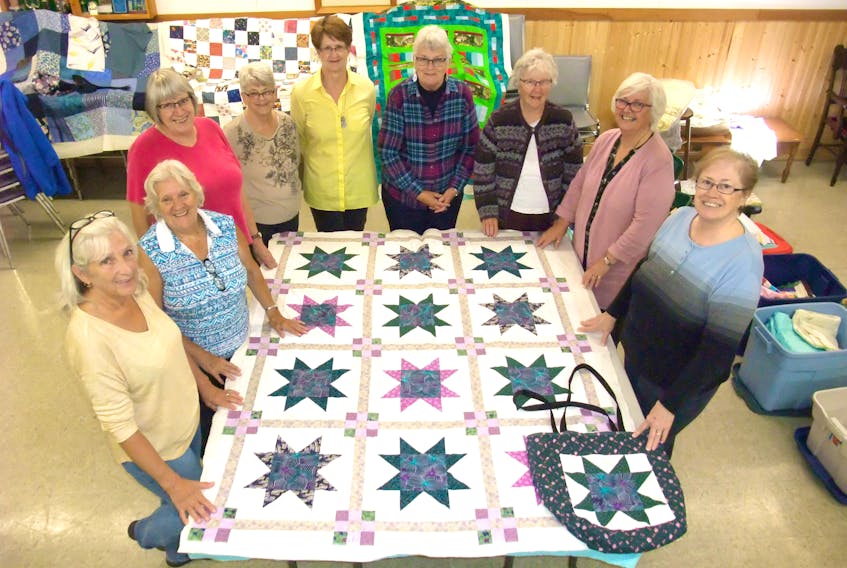 Members of Victoria Quilts Canada, Tantramar Chapter, recently gathered around one of the quilts they are making for a cancer patient. The chapter has about 20 members, including, (from left) Margo Gould, Dorothy Fitzgerald, Elizabeth Canning, Linda Gillis, Naomi Lamb, Pauline Lusby, Shirley Young, Gayle Janes, and Mary Farrow Sinclair. They made 70 quilts last year and close to 600 in the past nine years. Each quilt also comes with a custom-designed bag.