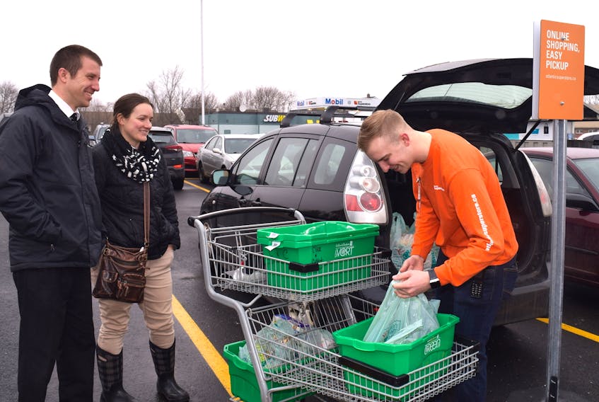Andrew Boone and his wife Sara of Truro watch as Atlantic Superstore front-end staffer Tim Trites loads their groceries into the car Wednesday morning. The Boones were one of the first customers to take advantage of the store's online shopping option, which now is also available in New Glasgow, Digby, Yarmouth and select stores in Halifax. The service  is to be available at all Atlantic Superstores across the province by mid April.
