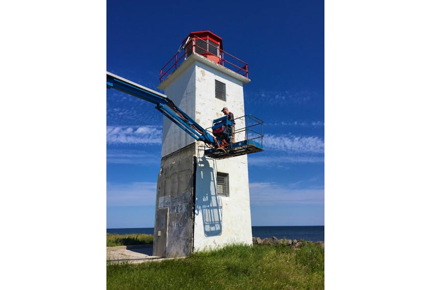 An employee with the Canadian Coast Guard begins work on the exterior walls of the Caribou Island lighthouse. Friends of Caribou Island are awaiting approval of its application to divest the lighthouse from the federal government so in the meantime the lighthouse is owned and maintained by the Coast Guard.