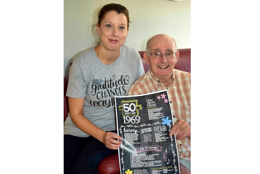 Glen Haven Manor resident Logan Chisholm and CCA lead Ashley Curtis take a look at a poster highlighting some of the local and world happenings back in 1969 when Glen Haven Manor first opened. The nursing home will celebrate its golden anniversary this Sunday from 4-6 p.m.