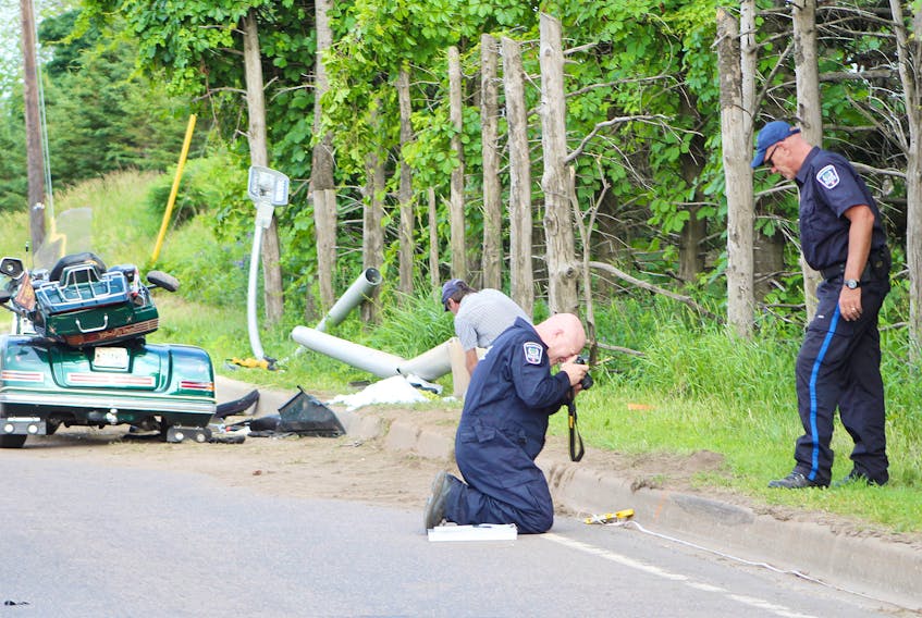 Traffic reconstructionists investigate at the site of a single-vehicle collision that left a 62-year-old P.E.I. woman dead on Sunday. The collision involved a three-wheel Gold Wing motorcycle that appeared to have struck a curb on Riverside Drive in Charlottetown.