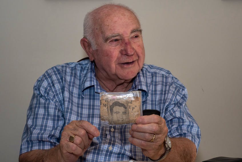 Harold Brine, the last surviving miner from a group of 12 who were entombed underground for 6 1/2 days after a 1958 underground upheaval in No 2 colliery at Springhill, N.S., . holds a newspaper clipping from the Halifax Herald showing a picture of him after his release from hospital. He has carried the fragile, yellowed clipping in his wallet for 60 years since the day he was released. - Wally Hayes photo
