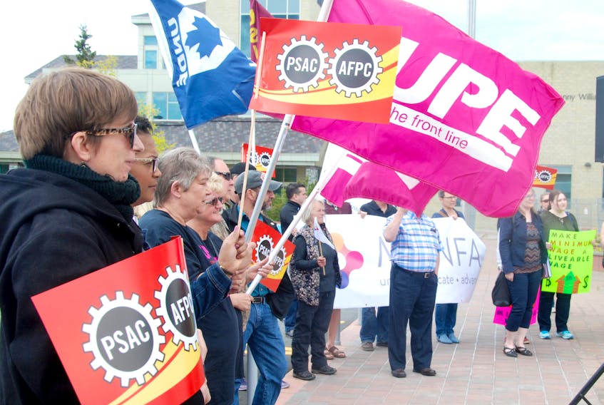 A group of supporters listen to Mary Shortall of the Newfoundland and Labrador Federation of Labour talk about the importance of fighting for a decent wage in this province during a Friday protest.