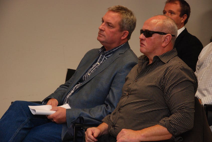 Fisheries and Land Resources Minister Gerry Byrne (left) and Terry Gardner listen to a speaker during Friday’s news conference in Corner Brook. The minister announced changes to provincial wildlife regulations.