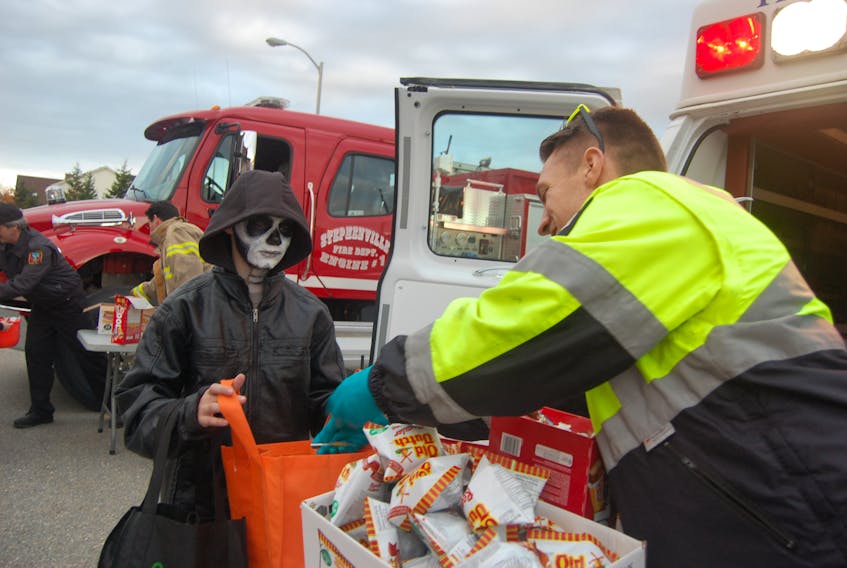 Twelve-year-old Jacen Gosse of Stephenville gets a treat from Tom Adams, instructor for the Paramedicine Program at College of the North Atlantic at the Bay St. George Crime Stoppers first ever Trunk ‘n’ Treat held in the parking lot of Stephenville High School.