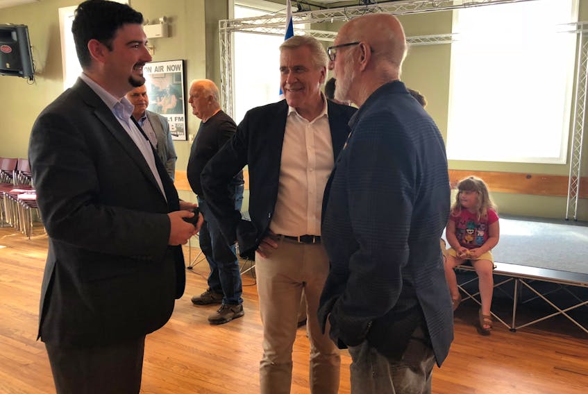 Tourism Minister Christopher Mitchelmore, left, Premier Dwight Ball and Cow Head Mayor Adrian Payne are seen during a funding announcement at the Norris Point Town Hall on Friday.