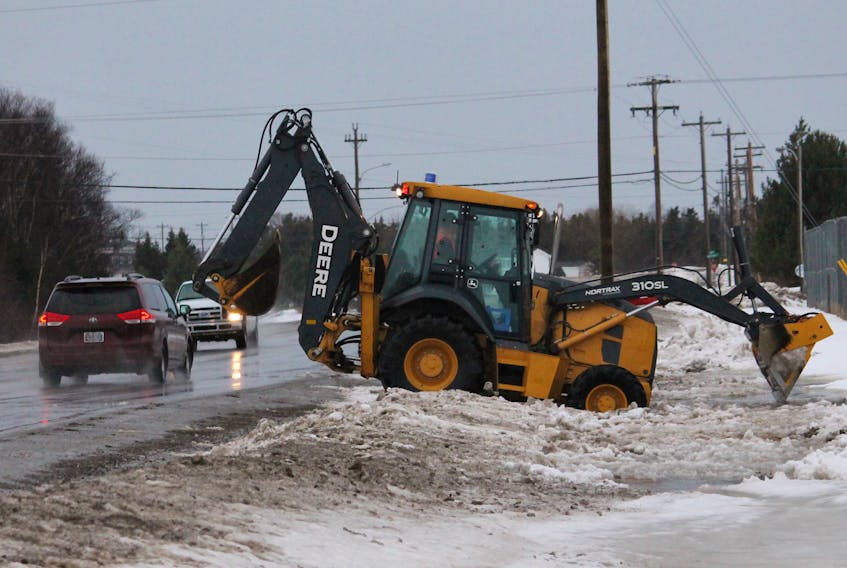The operator of a Town of Stephenville public works backhoe is seen working in a ditch between Minnesota Drive and Mayfield, where water had backed up on Monday morning and was getting close to a soccer equipment building.