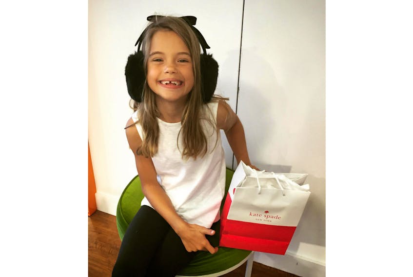Elle Delaney is pictured wearing the Kate Spade earmuffs she bought on a shopping trip in Florida almost four years ago. Her mom, Heather Delaney, wrote a note to the designer following her death on Tuesday.