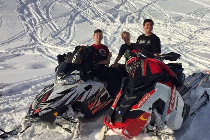 From left, Kayden Alexander, Adam House and Logan Reid pose for a photo while out for some fun sledding on the Lewis Hills.