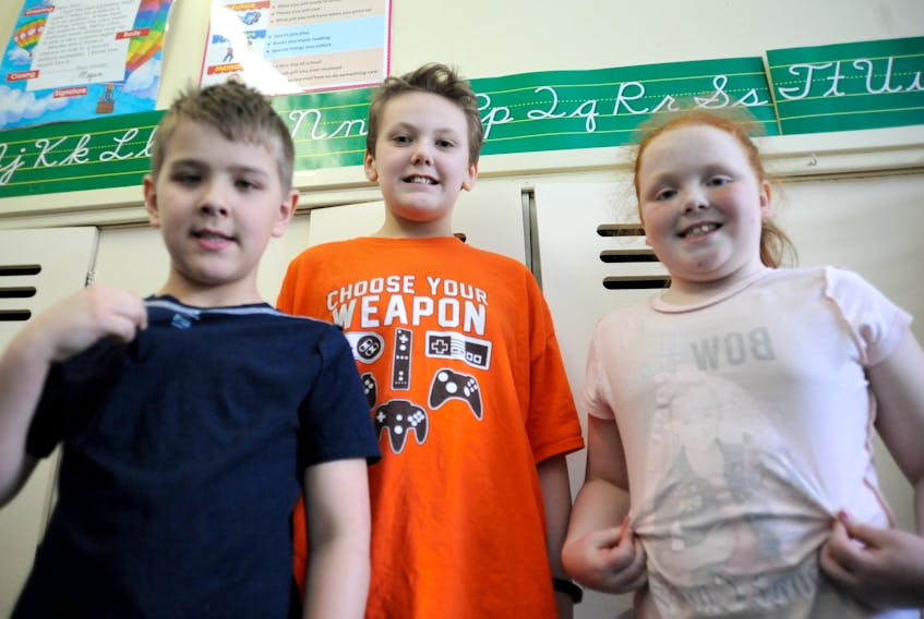 Jonathan MacDonald, centre, didn’t feel like wearing his clothes inside out to help raise awareness for autism Friday, but is glad his Sacred Heart Elementary schoolmates, including Braeden Barnes, left, and Heidi Butt took part in Inside Out for Autism Day in Corner Brook Friday.