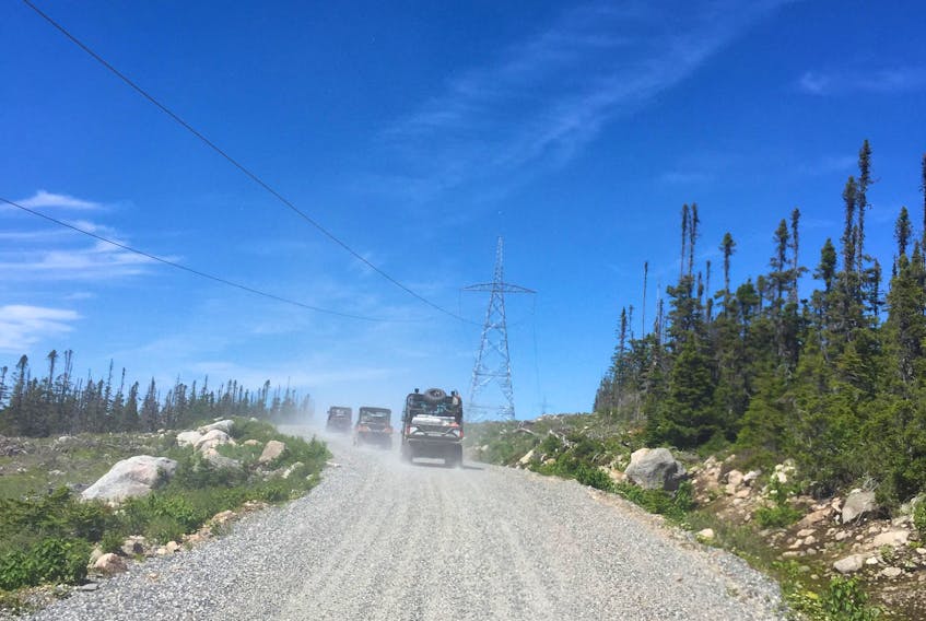 A group of all-terrain vehicles travel along the new access road coursing along the new hydroelectricity transmission line on the Northern Peninsula.