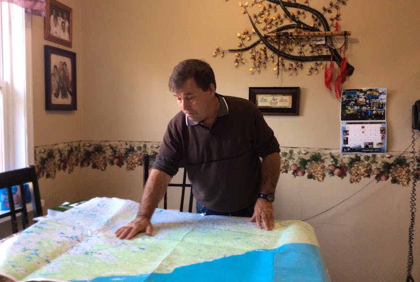 Melvin White, a member of the Qalipu Mi’kmaq First Nation Band looks over a map, in this handout image promoting the band’s traditional land use study.