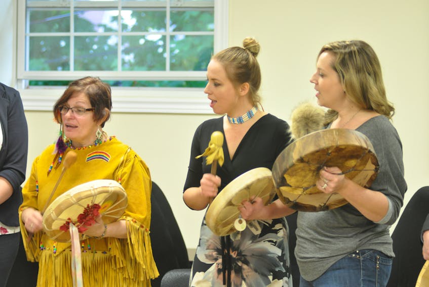 Michelle Matthews of the Corner Brook Aboriginal Women’s Association, left, and Souli’an drum and signing group members Sara Leah Hindy and Alison White sang a gifting song at the launch of the Moose Hide Campaign at the Qalipu First Nation Band office in Corner Brook on Friday.