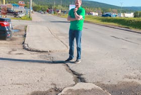 Deer Lake’s Mike Goosney stands next to one the three potholes he helped fix in the community last year.