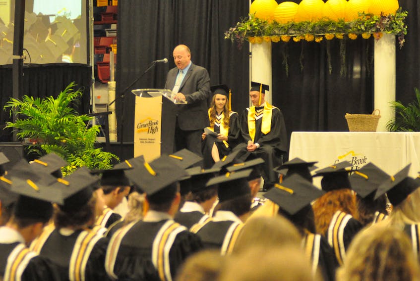 Vaughn Granter gives his final principal’s address to Corner Brook Regional High’s 2018 graduates during the school’s cap and gown ceremony at the Corner Brook Civic Centre on Thursday. Granter is retiring. Seated behind him are graduates Jadyn Normore and Noah Penney.