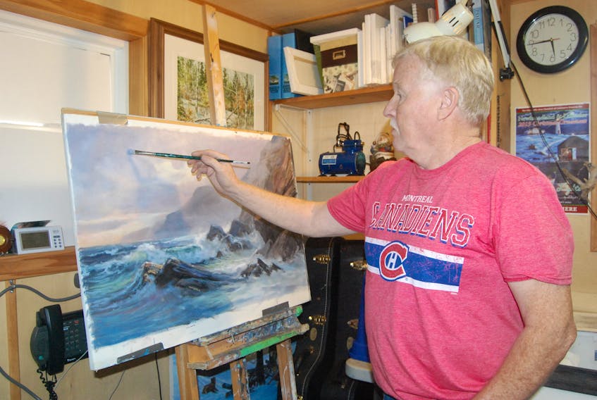 Artist Lloyd Pretty poses in his studio with an original painting he’s working on.