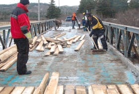 Volunteers with the Bay St. George Snowmobile/ATV Association work at replacing the deck on a bridge in Noel’s Pond, the fifth bridge members have redone the deck on in the past 12 months.