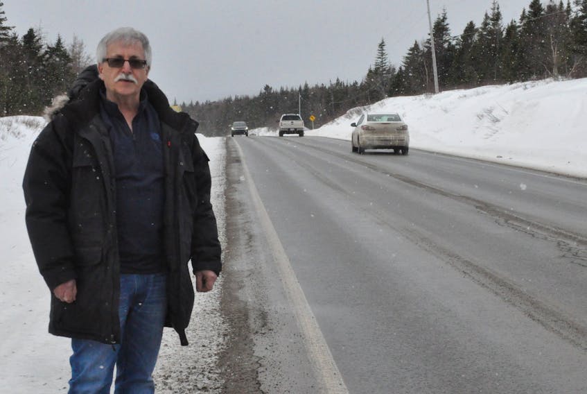 Bob Byrnes stands next to a section of the Hansen Highway where he said cracking has occurred in the center section.