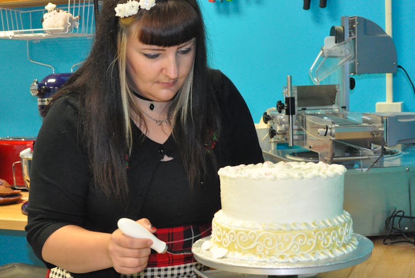 Kayla Walsh puts some seashell decorations on a birthday cake in the kitchen at her new bakery. Sugar Street Bakery is located on West Street in Corner Brook and is expected to open on July 28.