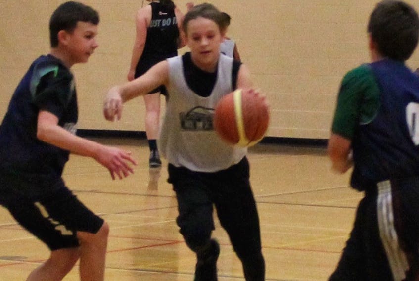 Mason Pawley of the Celtics dribbles between Ryan Lushman (left) and Brodie Miller of the Warriors in the Humber Valley Basketball Summer League’s U12  male final earlier this week. The Celtics won 34-30.