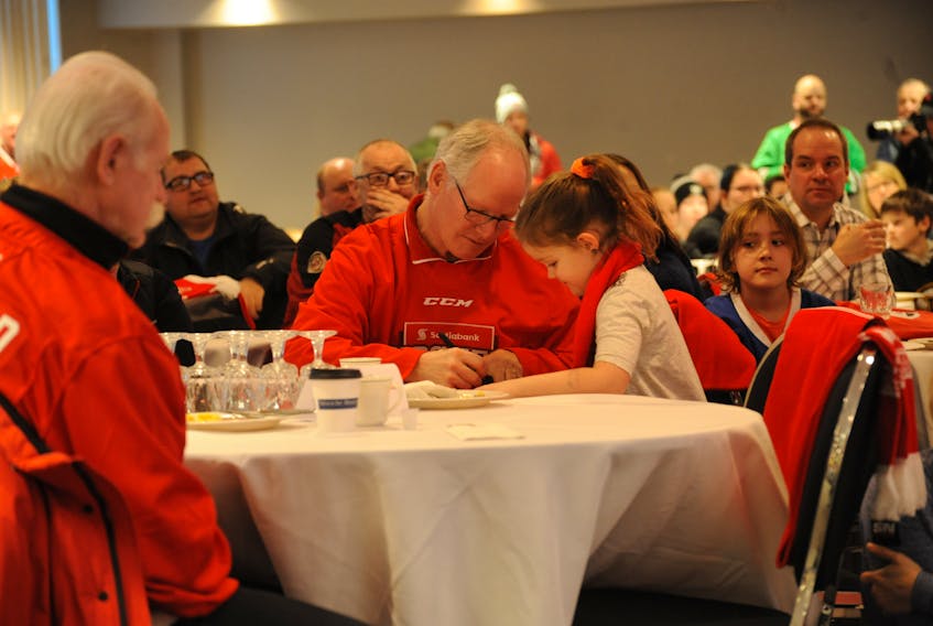 Lydia Rashleigh, 6, gets an autograph from two-time Stanley Cup champion Mark Napier during the Scotiabank Hockey Day in Canada breakfast event in Corner Brook Friday.