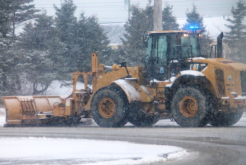 A plow operated by an employee of the public works department of the Town of Stephenville is seen pushing snow on Boland Drive this morning, the first day of spring.