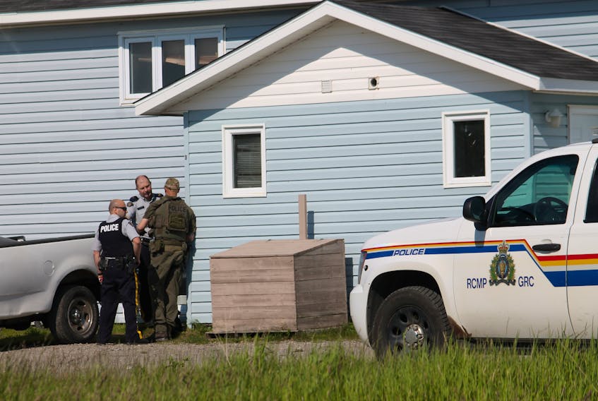 Members of the Bay St. George RCMP and Police Dog Services West are seen discussing the situation outside a Stephenville Crossing home where a man was barricaded inside on Wednesday afternoon.