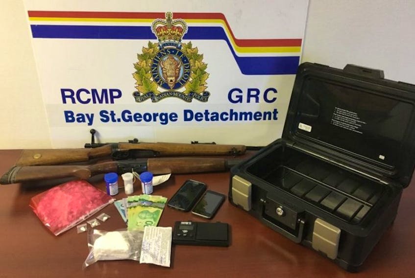 Members of the RCMP allege they located about a half pound of cocaine, a quantity of Canadian currency and two firearms inside a home in Flat Bay last week.