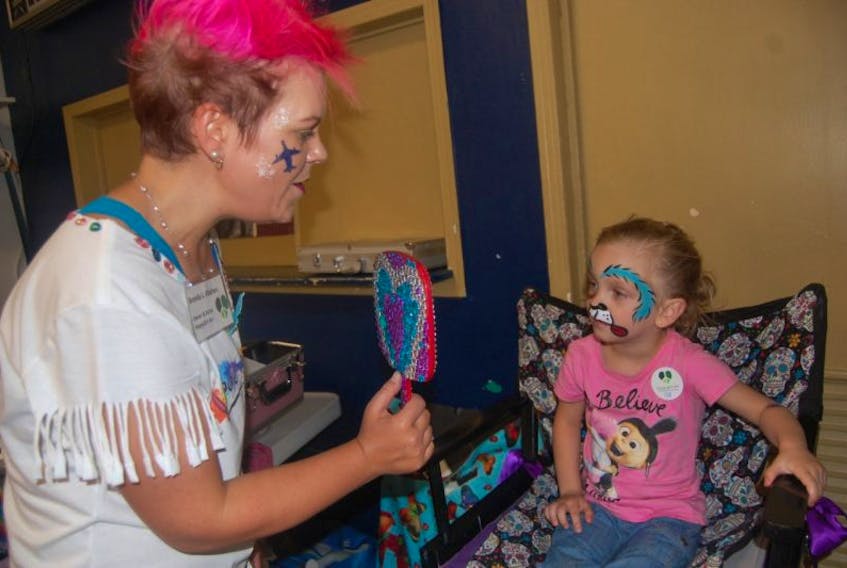 Three and a half-year-old Abigail White, daughter of Jelissa White of Stephenville, has a look in the mirror after having a Puppy Dog face painted on her by Brenda Kitchen, facepainter.