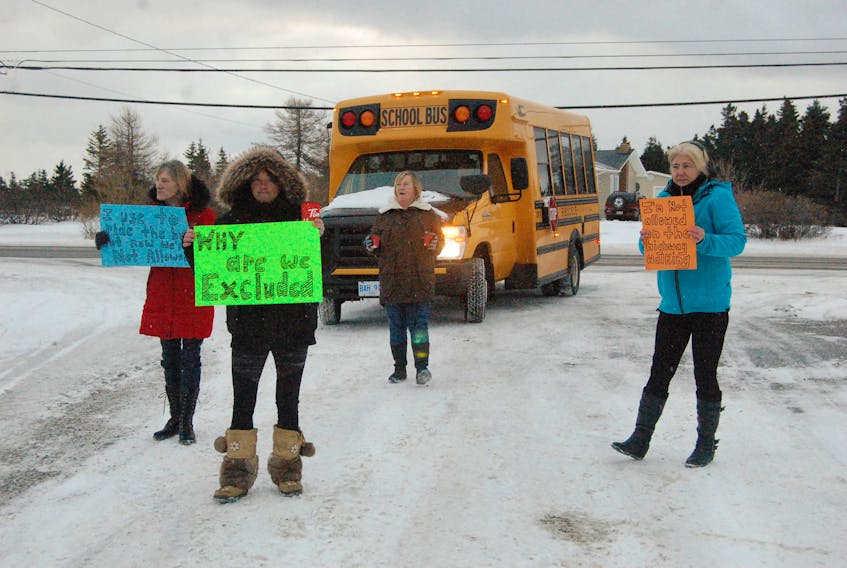Demonstrators who blocked buses at St. Thomas Aquinas School in Port au Port East this morning are seen marching ahead of one of the buses. They include from left: Phoebe Hoskins, Sabrina Humber, Beverly Hoskins and Bernadette Benoit.